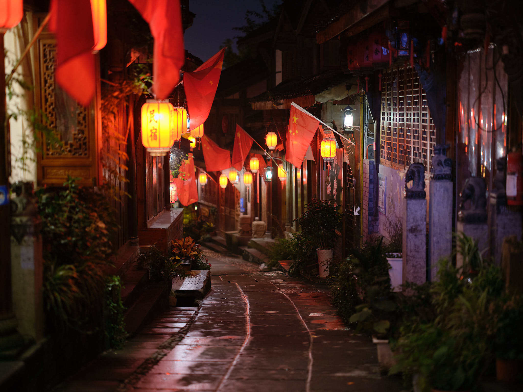 Chinese flags in a wet alley in Dujiangyan ancient town