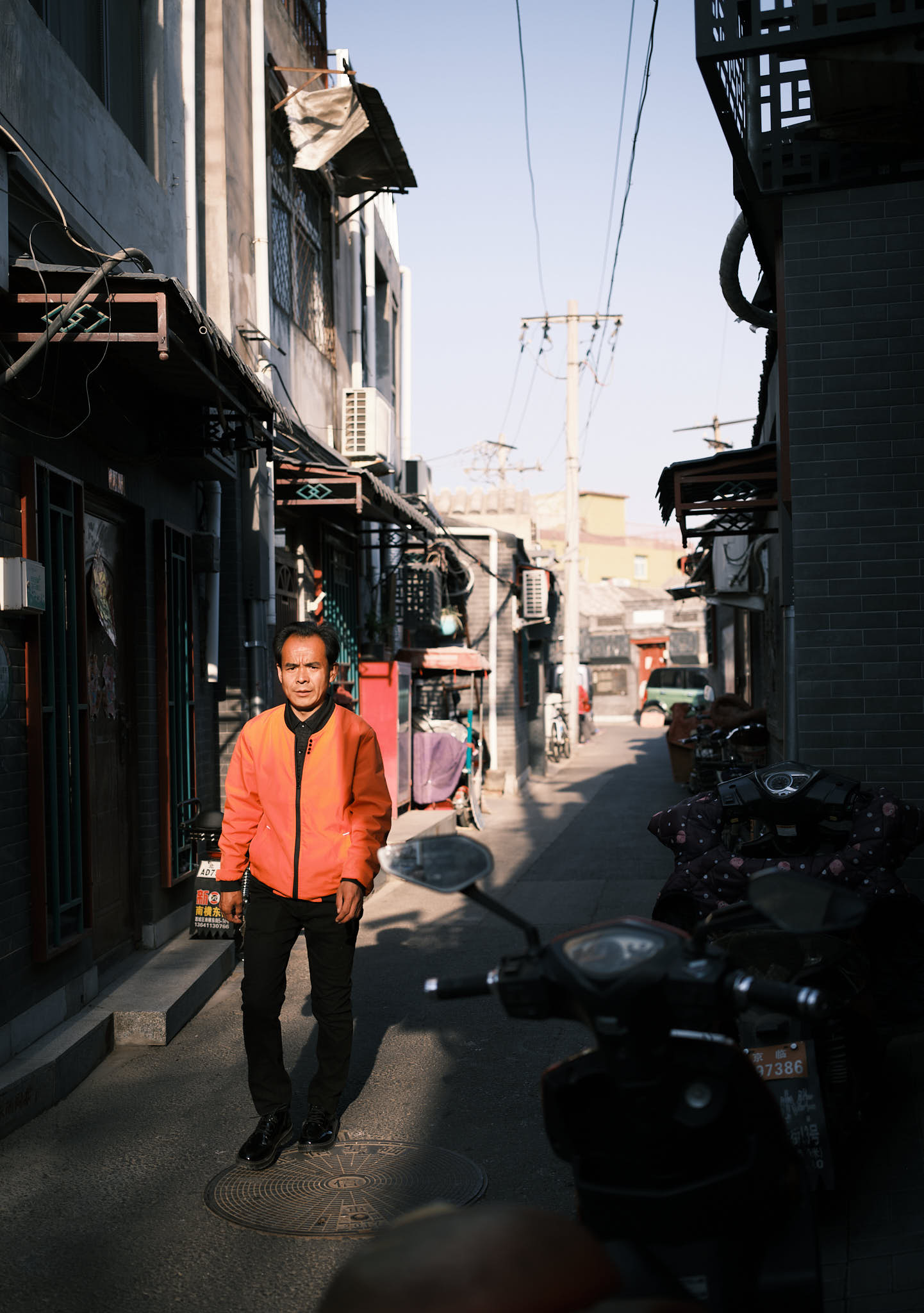 Man walking in sunset in alley in Qianmen Hutong