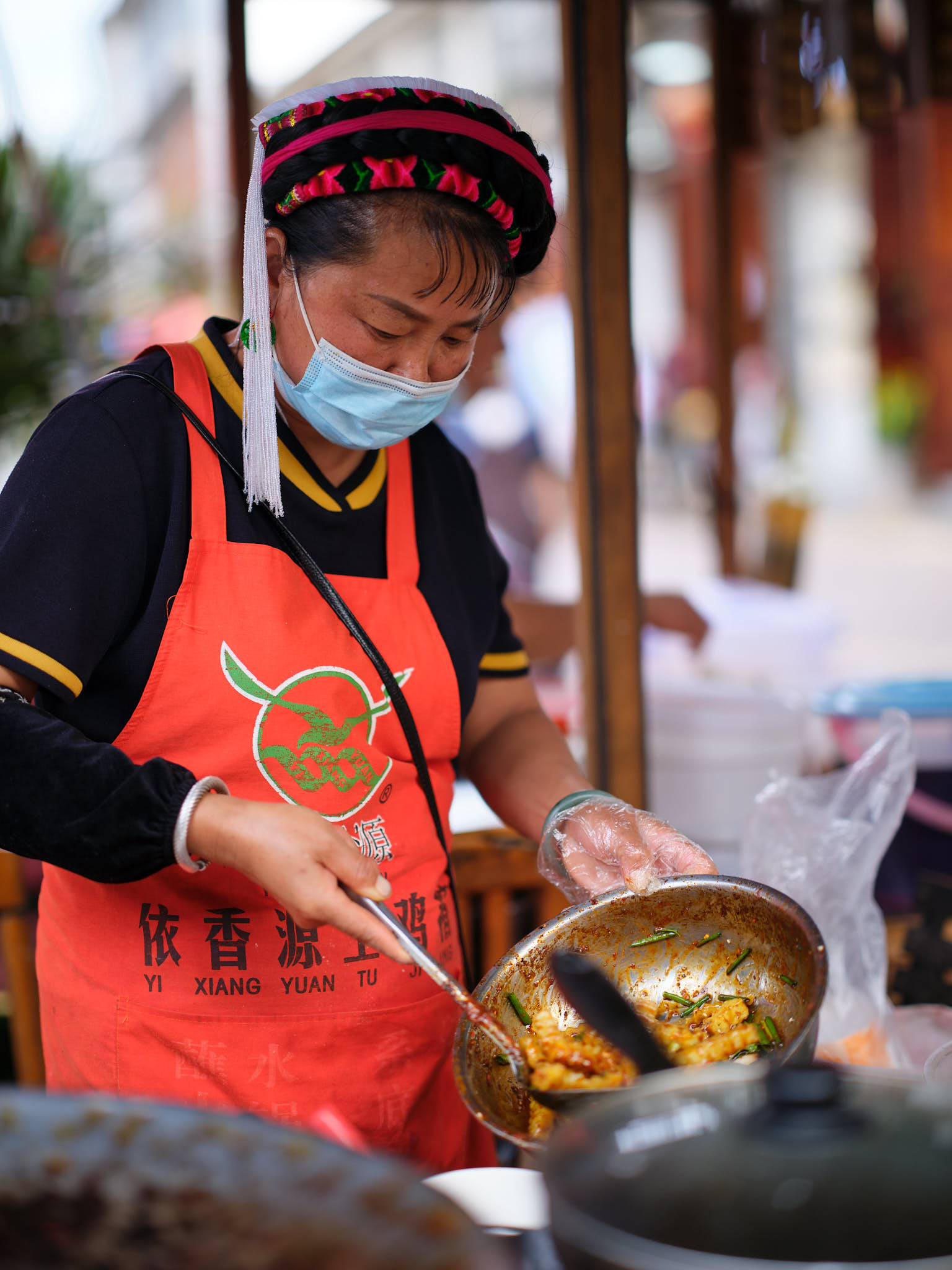 Woman cooking spicy fries with cumin on the streets of Shuanglang