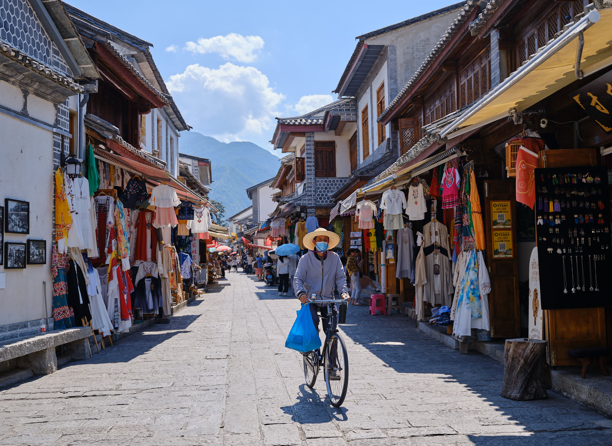 Man riding a bicycle with a farmer's hat in Xizhou ancient town