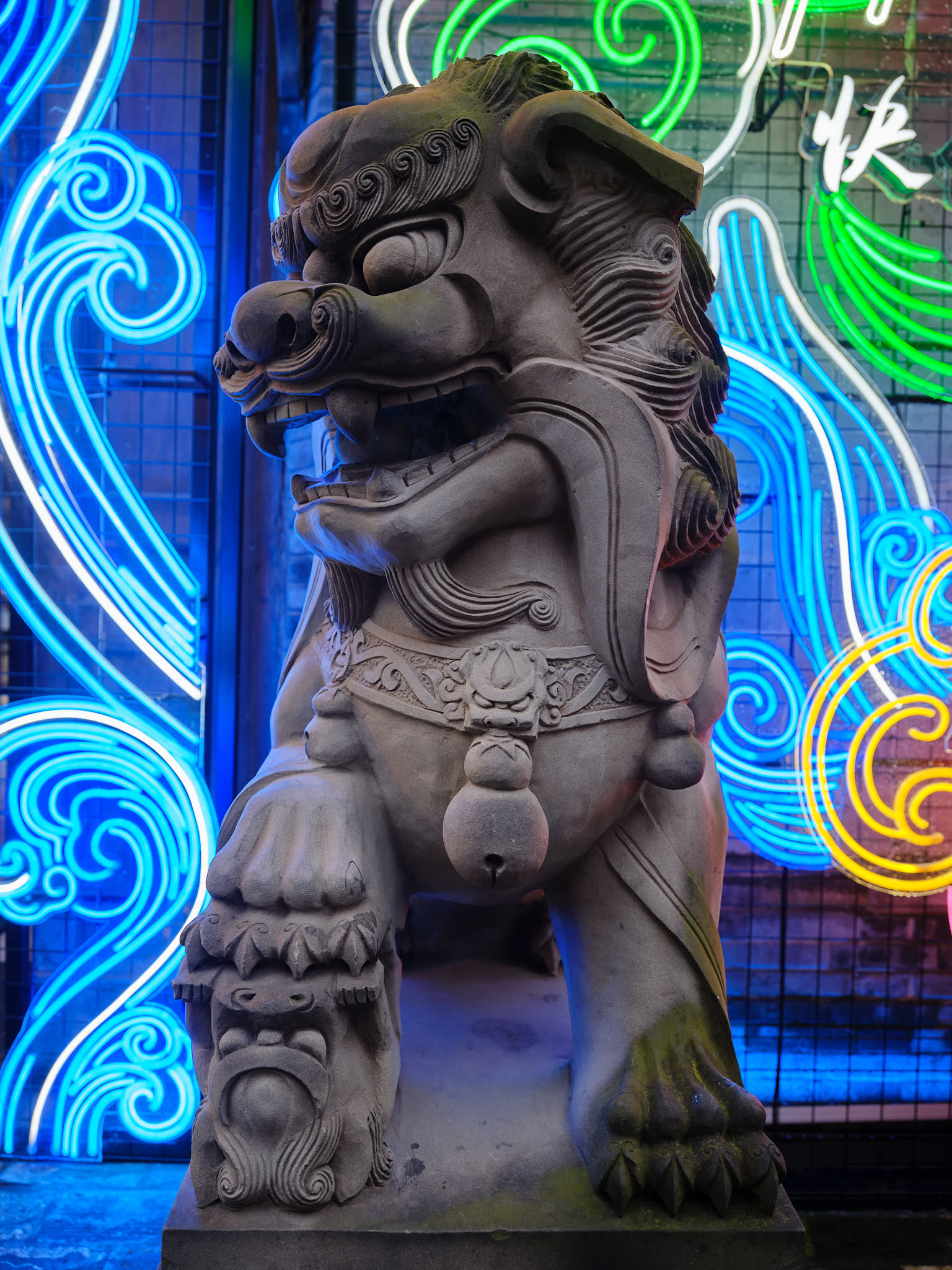 Neon lights brighten a Lion statue at Kuanzhai